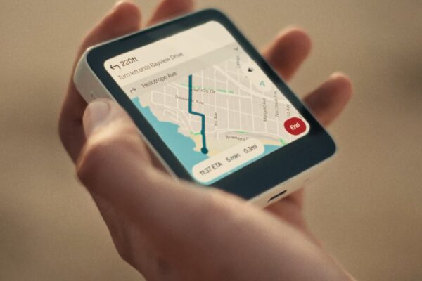 The Meadow ultra-compact smartphone with minimalist design, no browser, social media, or email, displayed on a wooden desk with natural lighting