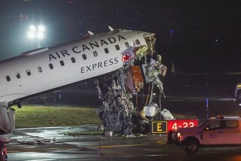 Air Canada aircraft after runway collision with fire truck at LaGuardia Airport, emergency crews surrounding damaged plane